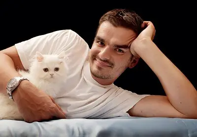 an image showing a man lying with white kitten